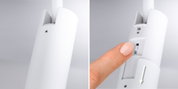Close-up of white plastic housing with slider switch and finger adjusting LED lighting control