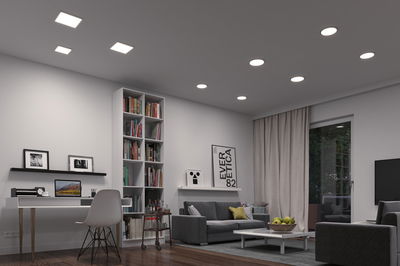 Moderne woonkamer met witte LED-plafondlampen, grijze bank, houten vloer, stijlvolle sfeerverlichting