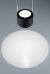 Black round metal LED pendant light casting bright circle for modern interior lighting