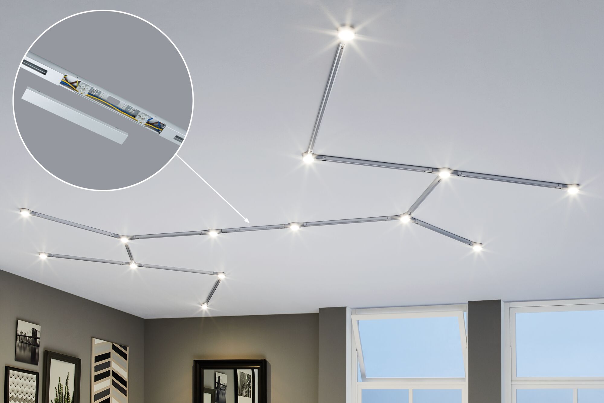 Modular silver LED track lighting with warm white light on white ceiling in modern living room.
