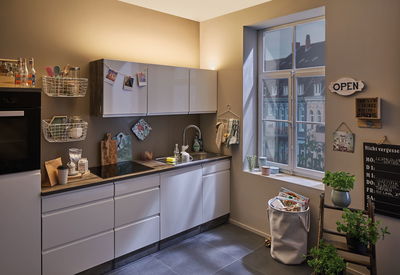 Cuisine moderne avec façades blanches, plan de travail en bois et éclairage mural LED chaud pour une ambiance cosy