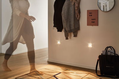 Wohnzimmer mit warmweißen LED-Nachtlichtern an Wand, Holzfußboden und Teppich mit geometrischem Muster