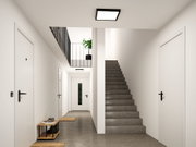 Modernes Treppenhaus mit grauem Betonboden, weißen Türen und quadratischer Deckenleuchte in Schwarz