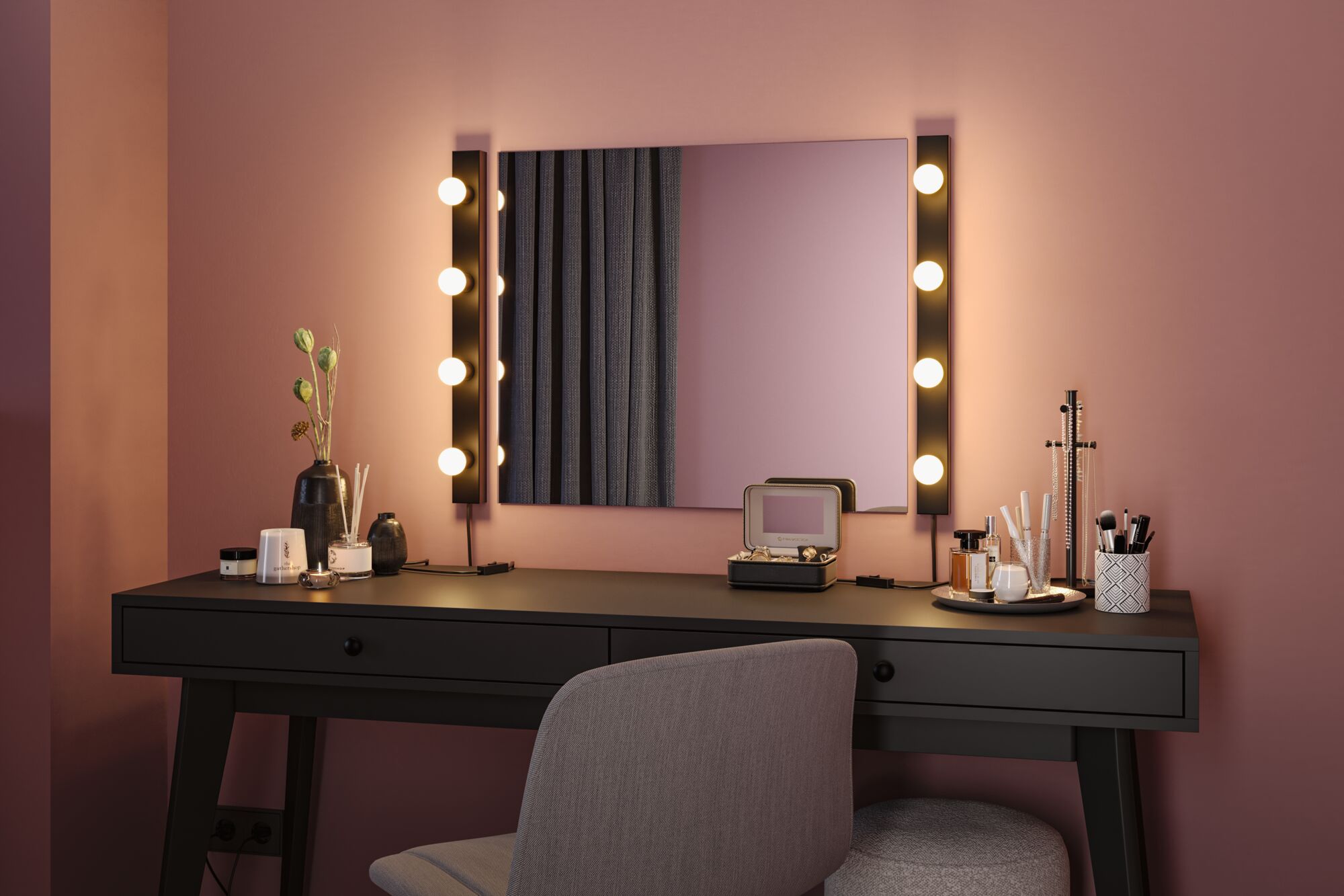 Schwarzer Schminktisch mit Spiegel und warmweißen LED-Leuchten an rosa Wand für Make-up Bereich
