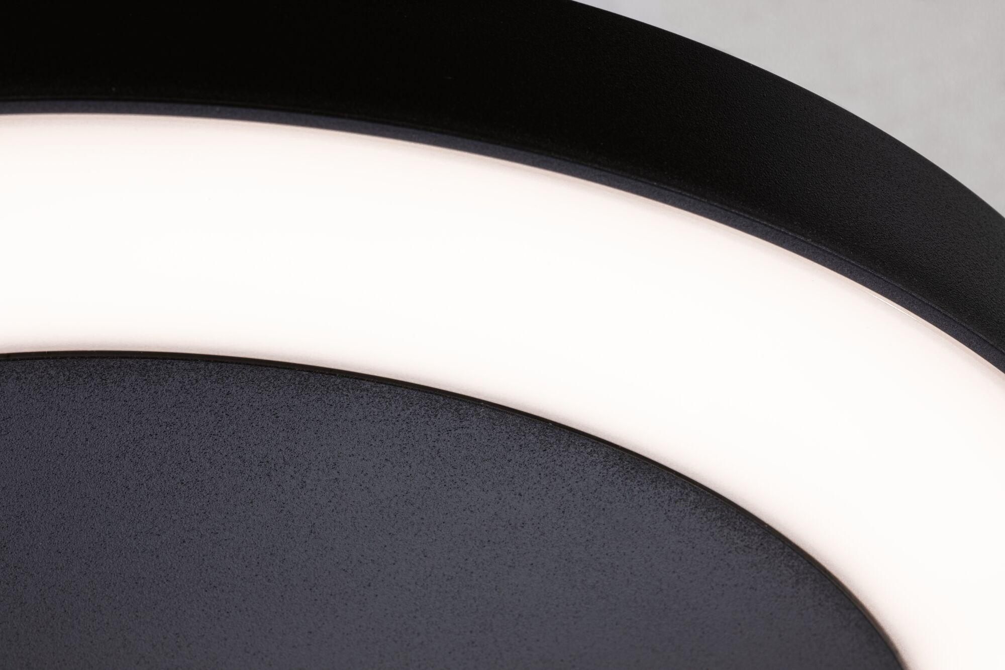 Close-up of black LED ceiling light with white glowing ring made of metal and plastic