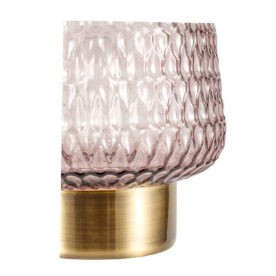 Close-up of pink textured glass lampshade with gold metal base for elegant home lighting