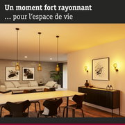 Salon moderne avec suspensions et appliques murales jaunes diffusant une lumière chaude et accueillante