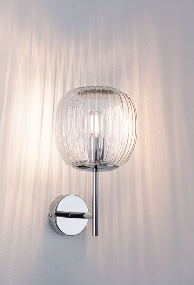 Wall lamp with ribbed clear glass and chrome metal, modern indoor lighting fixture.
