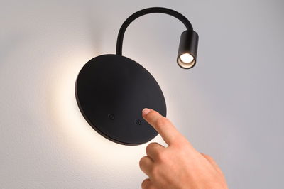 Black LED wall light with flexible reading arm and touch switch, modern design for living spaces