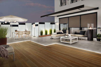 Moderne terras met houten vloer, LED-verlichting, loungemeubilair en buitenstaande en tafellampen