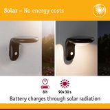 Black solar wall light with motion sensor on white wall, battery charges 8 hours by sunlight