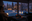 Winter garden with LED decorative lights shaped as stars and trees in snowy garden at dusk.