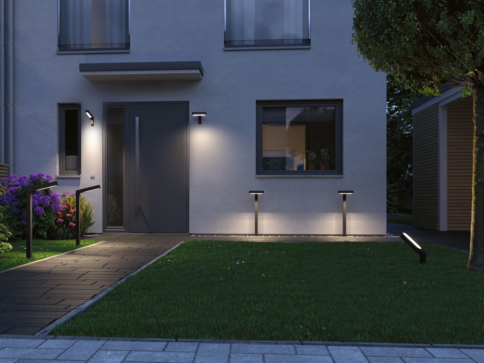Moderne Außenbeleuchtung mit schwarzen LED-Wandleuchten und Gartenpfosten an Hausfassade und Weg.