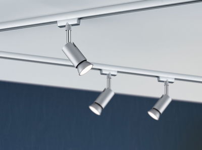 Trois spots LED métalliques argentés sur rail de plafond pour éclairage intérieur moderne