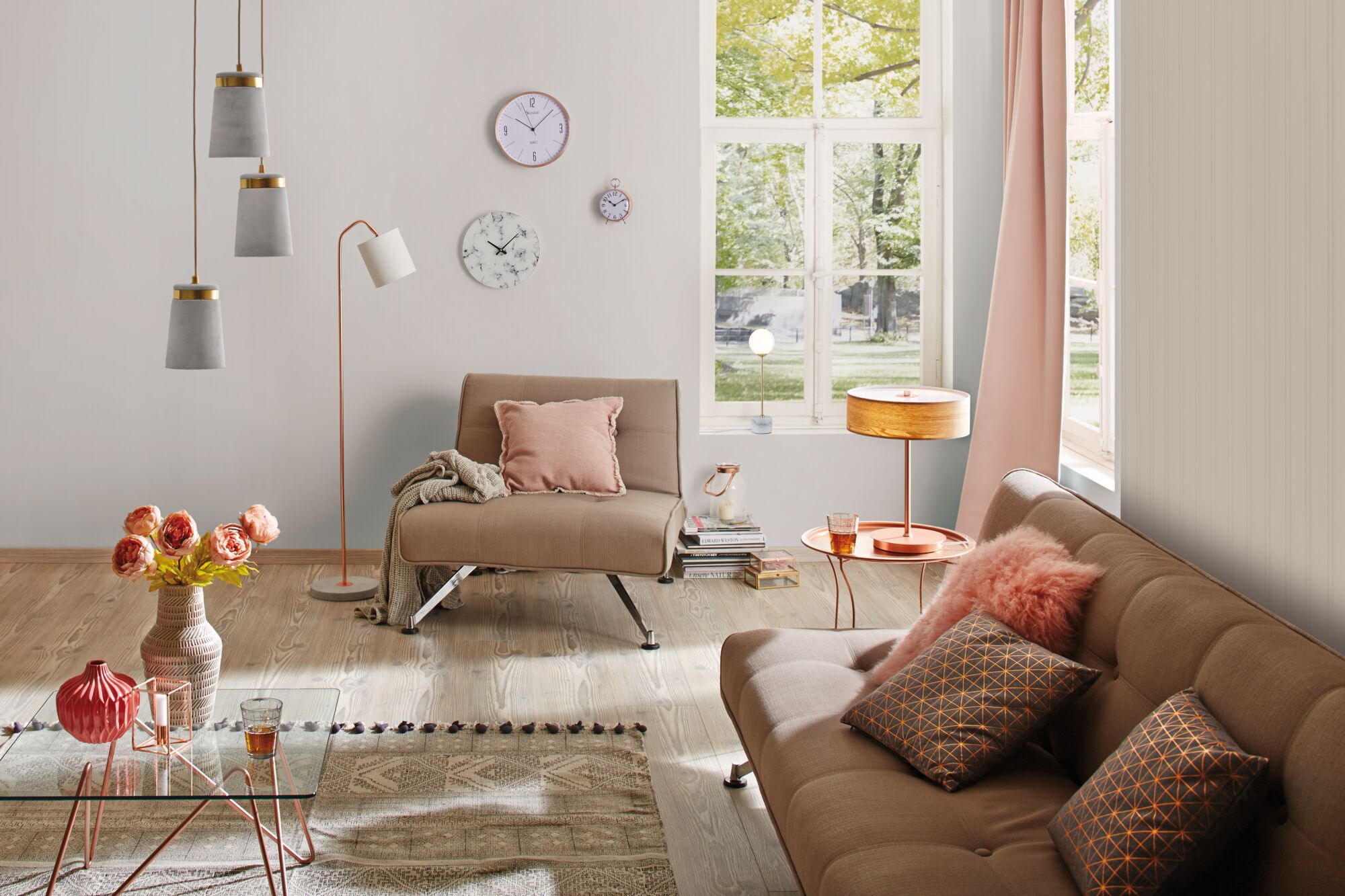 Modernes Wohnzimmer mit beigen Polstermöbeln, rosa Kissen und dekorativen Lampen für gemütliche Beleuchtung.