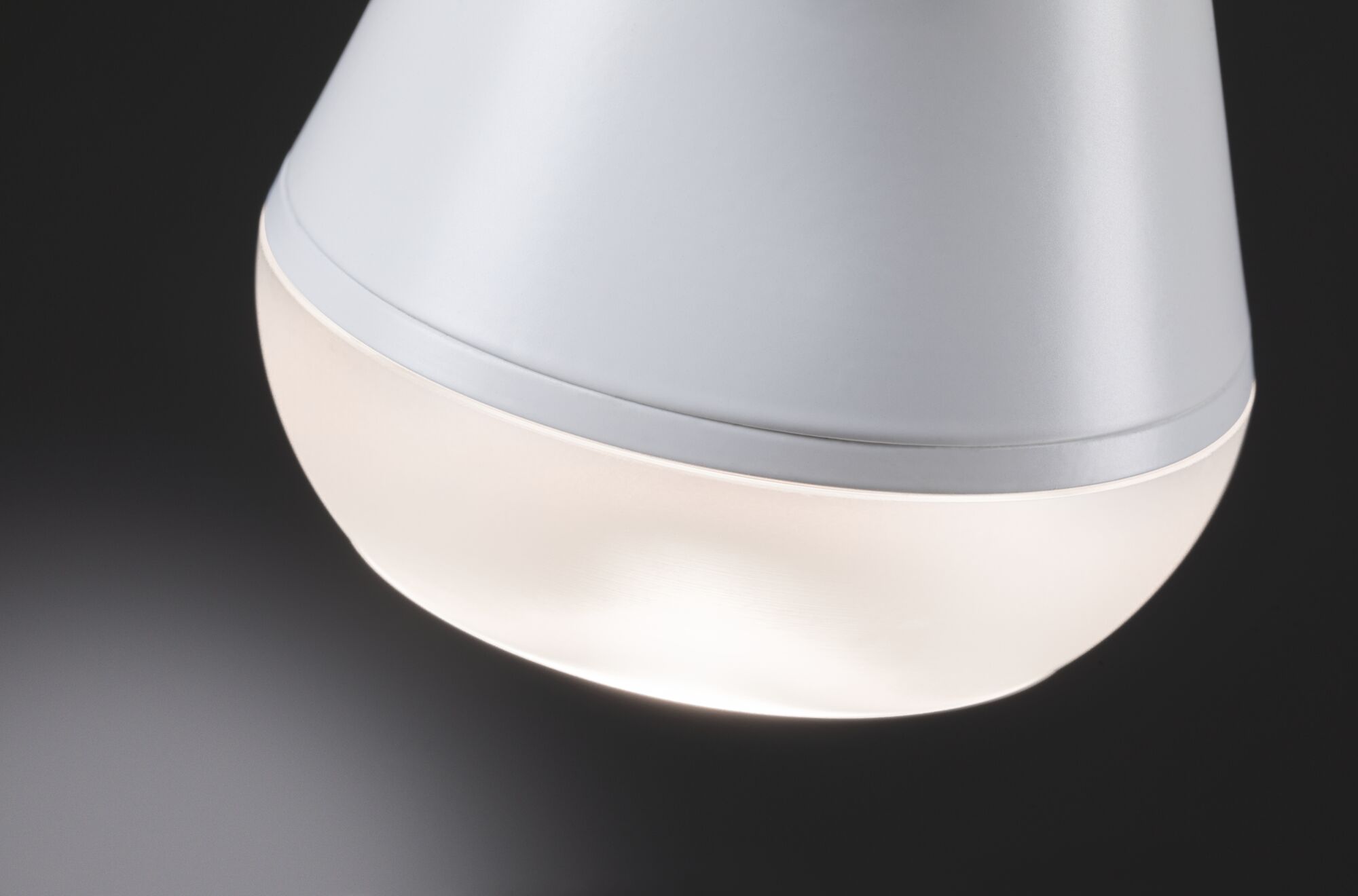 Gros plan d'une lampe LED blanche en plastique mat avec lumière blanche chaude pour intérieur