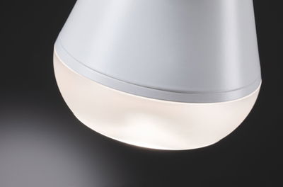 Gros plan d'une lampe LED blanche en plastique mat avec lumière blanche chaude pour intérieur