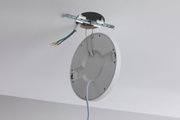 Plafonnier rond blanc en plastique avec câble et fils apparents pour installation.
