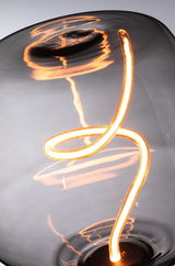 Close-up of warm glowing LED filament bulb with curved grey glass for ambient home lighting