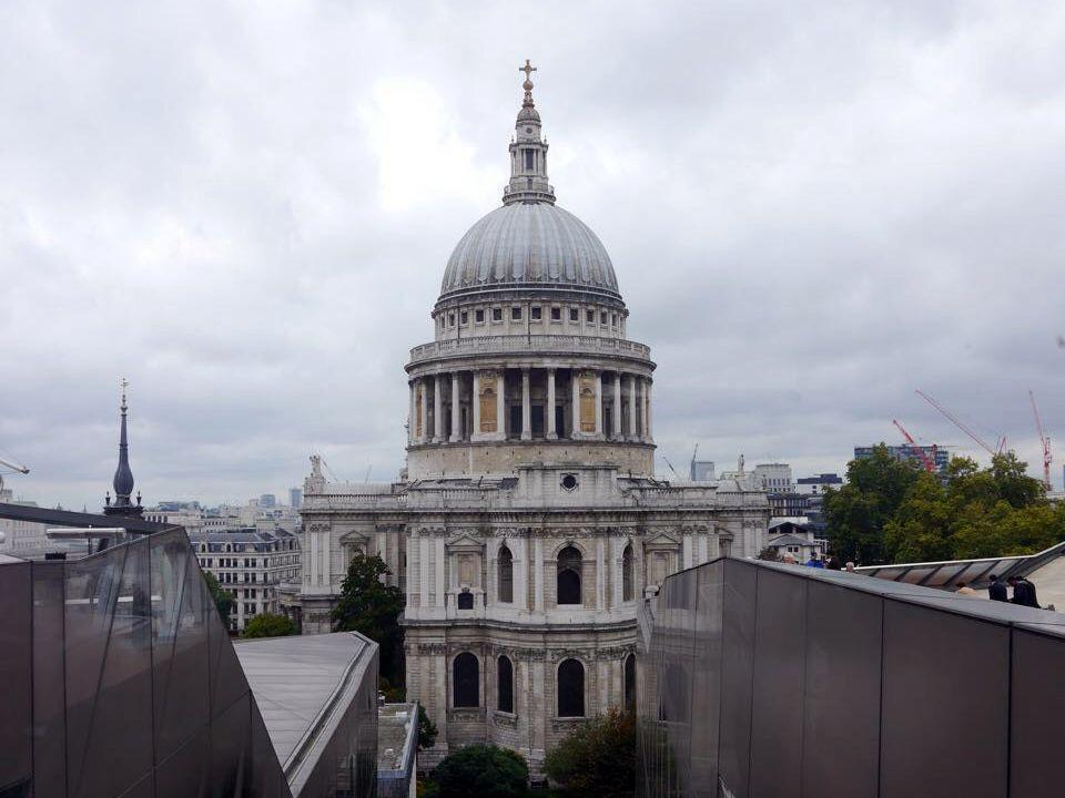 Historisches Gebäude mit großer Kuppel und Säulen vor bewölktem Himmel in Stadtansicht