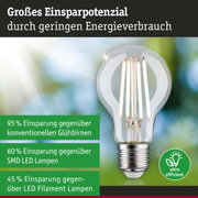 Energiesparpotenzial einer LED-Glühbirne mit klarem Glas und silbernem Sockel vor grün-blauem Hintergrund