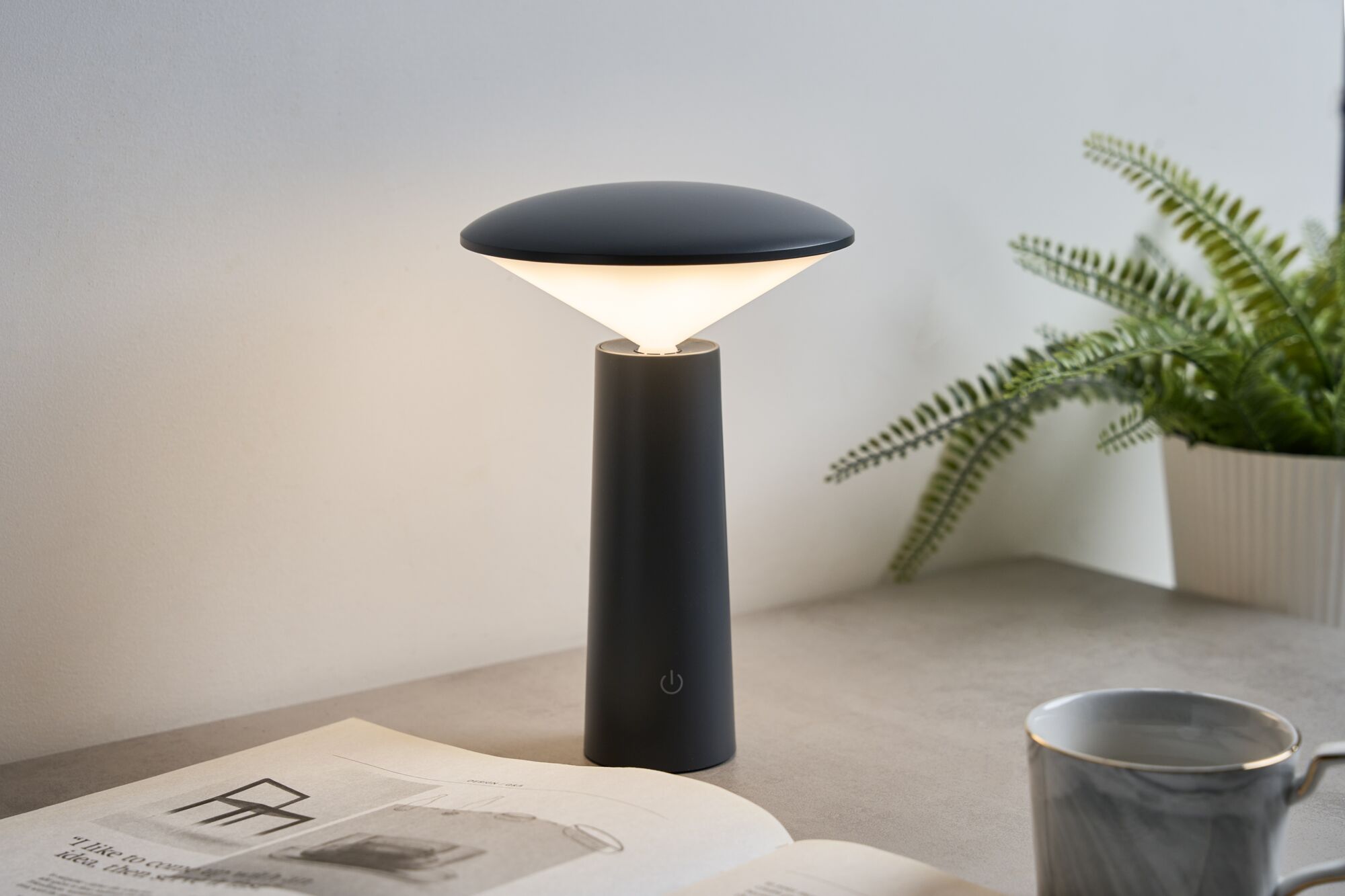 Modern black LED table lamp with conical base and warm white light for ambient lighting in living spaces