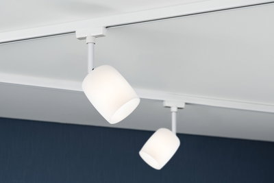 Zwei weiße Deckenstrahler mit mattem Glas und weißem Metallgehäuse an Schienensystem für Wohnraumbeleuchtung