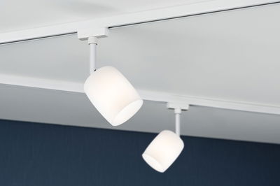 Zwei weiße Deckenstrahler mit mattem Glas und weißem Metallgehäuse an Schienensystem für Wohnraumbeleuchtung