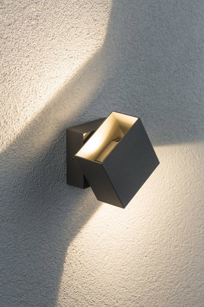Moderner schwarzer Aluminium-Wandstrahler mit warmweißem Licht an strukturierter Wand für Außenbeleuchtung