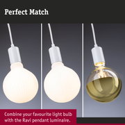 Three white pendant luminaires with different light bulbs on white cords against dark background