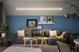 Moderne woonkamer met grijze bank, blauwe muur en minimalistische LED-plafondlamp voor sfeerverlichting