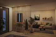 Modernes Wohnzimmer mit Holzlamellen-Trennwand, beigem Sofa und warmweißen LED-Einbaustrahlern