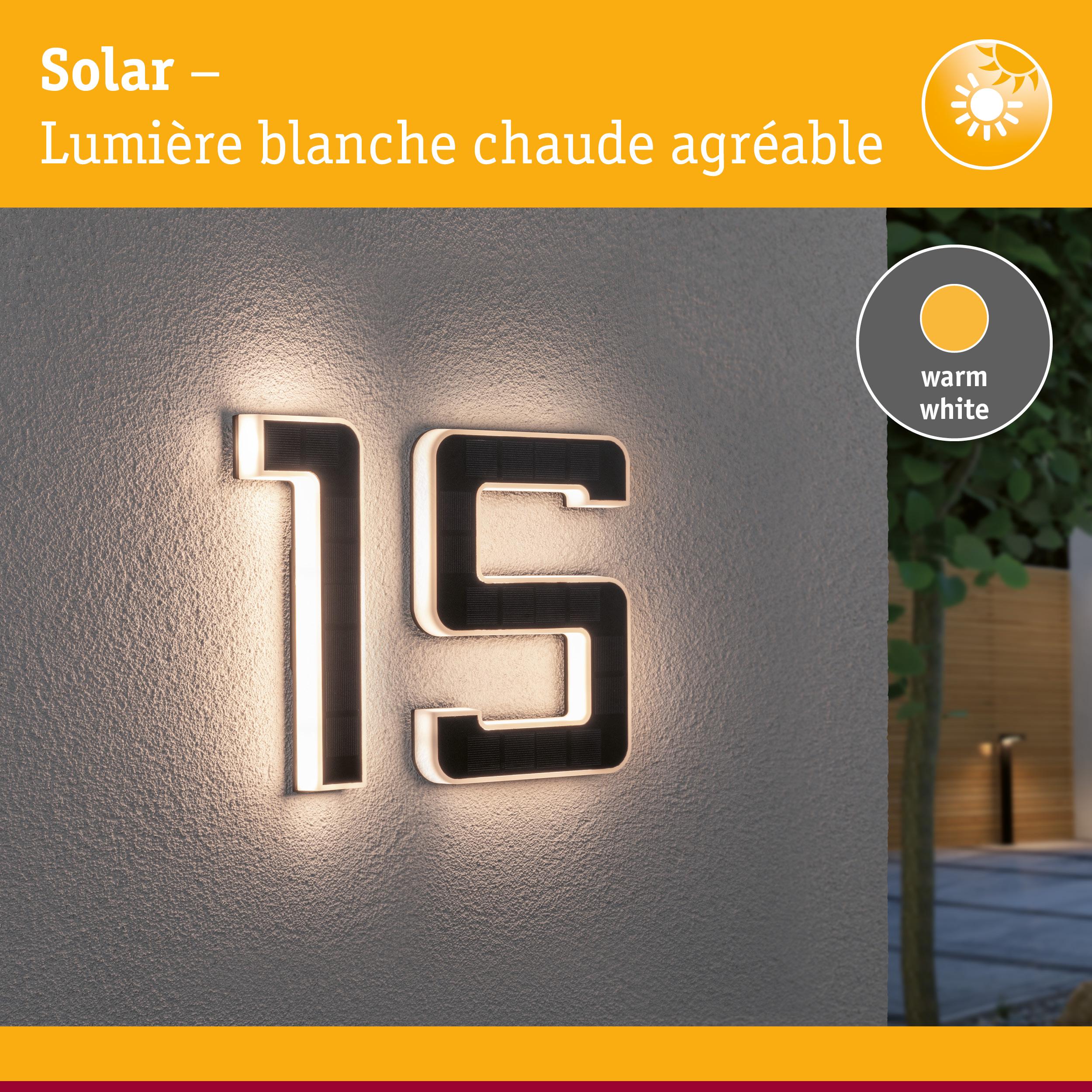 Numéro de maison solaire 15 en matériau noir avec lumière LED blanc chaud sur mur gris