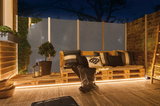 Gezellig houten palletbankje met kussens en LED-verlichting op terras in de avond