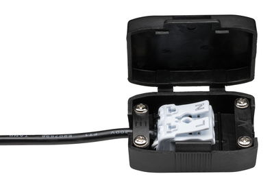 Black plastic connector clamp with open lid and attached cable for electrical wiring applications