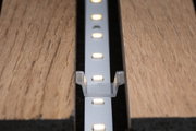 LED-Lichtleiste in Aluminiumhalterung zwischen zwei Holzplatten für moderne Beleuchtungslösungen