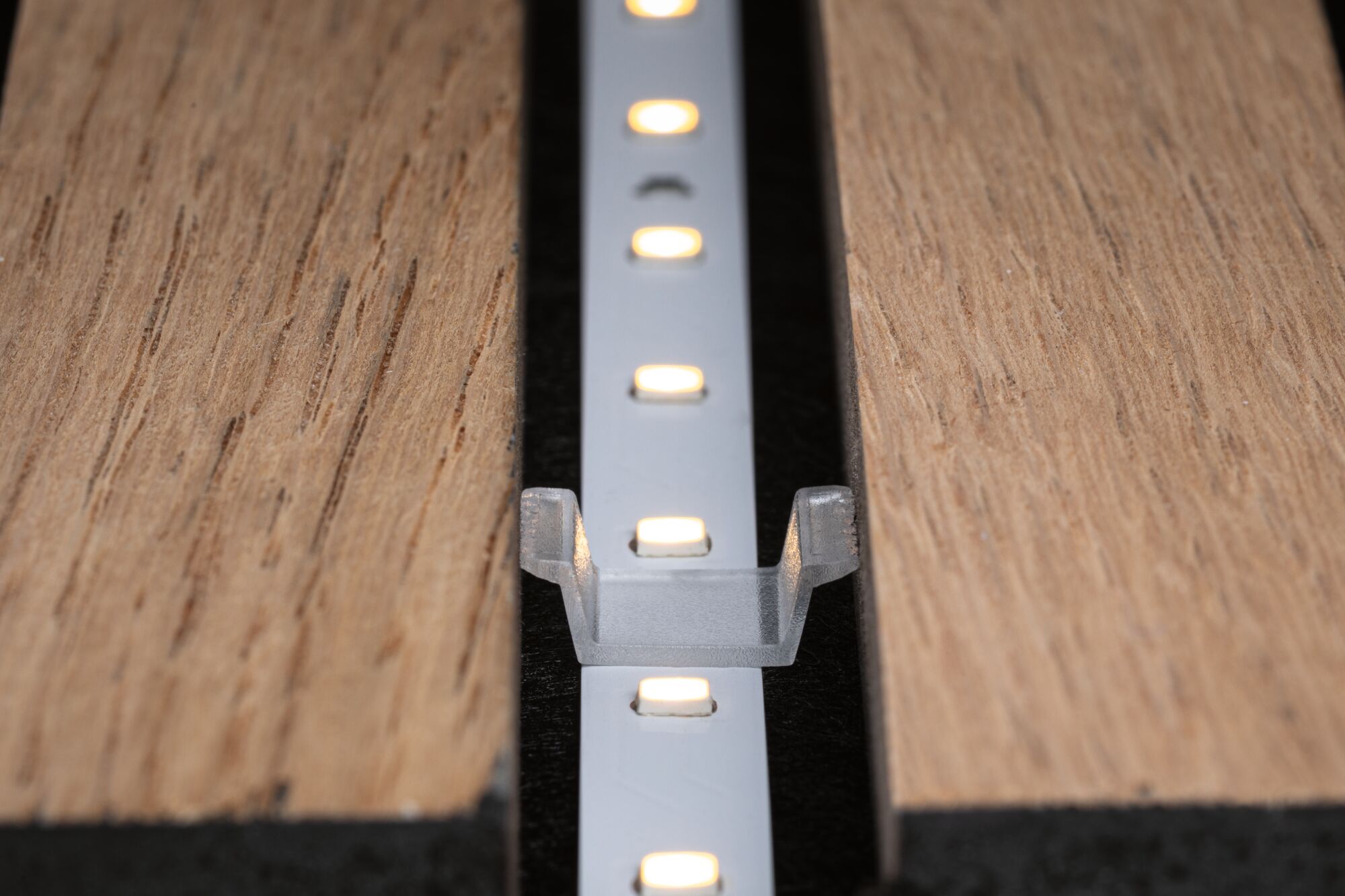 LED-Lichtleiste in Aluminiumhalterung zwischen zwei Holzplatten für moderne Beleuchtungslösungen
