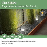 Eingelassene LED-Gartenleuchten mit warmweißem Licht in Kiesbeet neben Holzrahmen für Terrasse