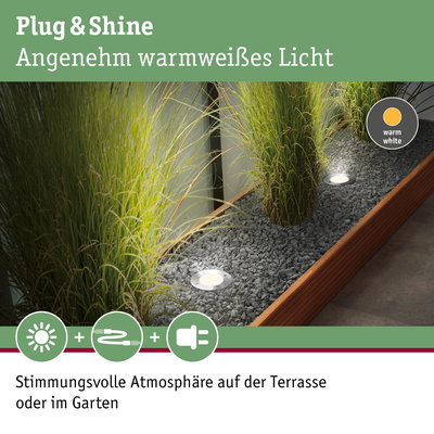 Eingelassene LED-Gartenleuchten mit warmweißem Licht in Kiesbeet neben Holzrahmen für Terrasse