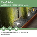 Eingelassene LED-Gartenleuchten mit warmweißem Licht in Kiesbeet neben Holzrahmen für Terrasse