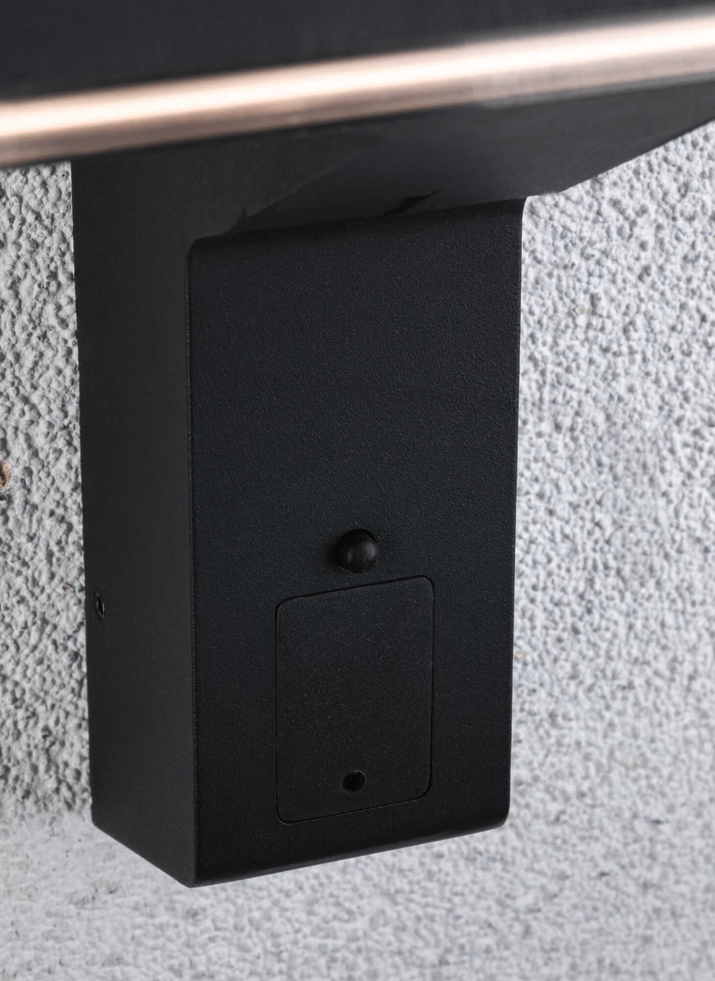 Boîtier métallique noir avec petite trappe fixé sur mur blanc texturé pour éclairage extérieur