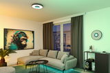 Modernes Wohnzimmer mit grauem Stoffsofa, zwei schwarzen Beistelltischen und runder Deckenleuchte mit LED-Licht