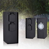 Black outdoor sockets with protective covers and mechanical timer for garden lighting control.