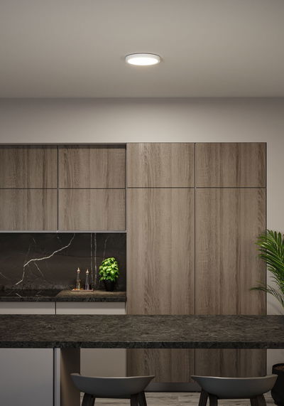 Runde weiße LED-Deckenleuchte in moderner Küche mit Holzfronten und schwarzer Arbeitsplatte