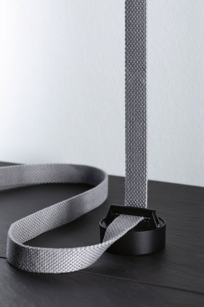 Grey textile strap with black plastic buckle on dark surface for lighting accessory use.