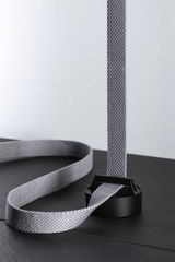 Sangle textile grise avec boucle en plastique noir sur surface sombre pour accessoire d'éclairage.