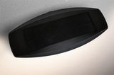 Sort solcellelampe med rektangulært solpanel og indirekte lys på hvid væg