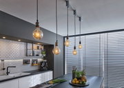 Moderne Pendelleuchten mit Glühbirnen in grauer Küche mit weißen Fliesen und Jalousien