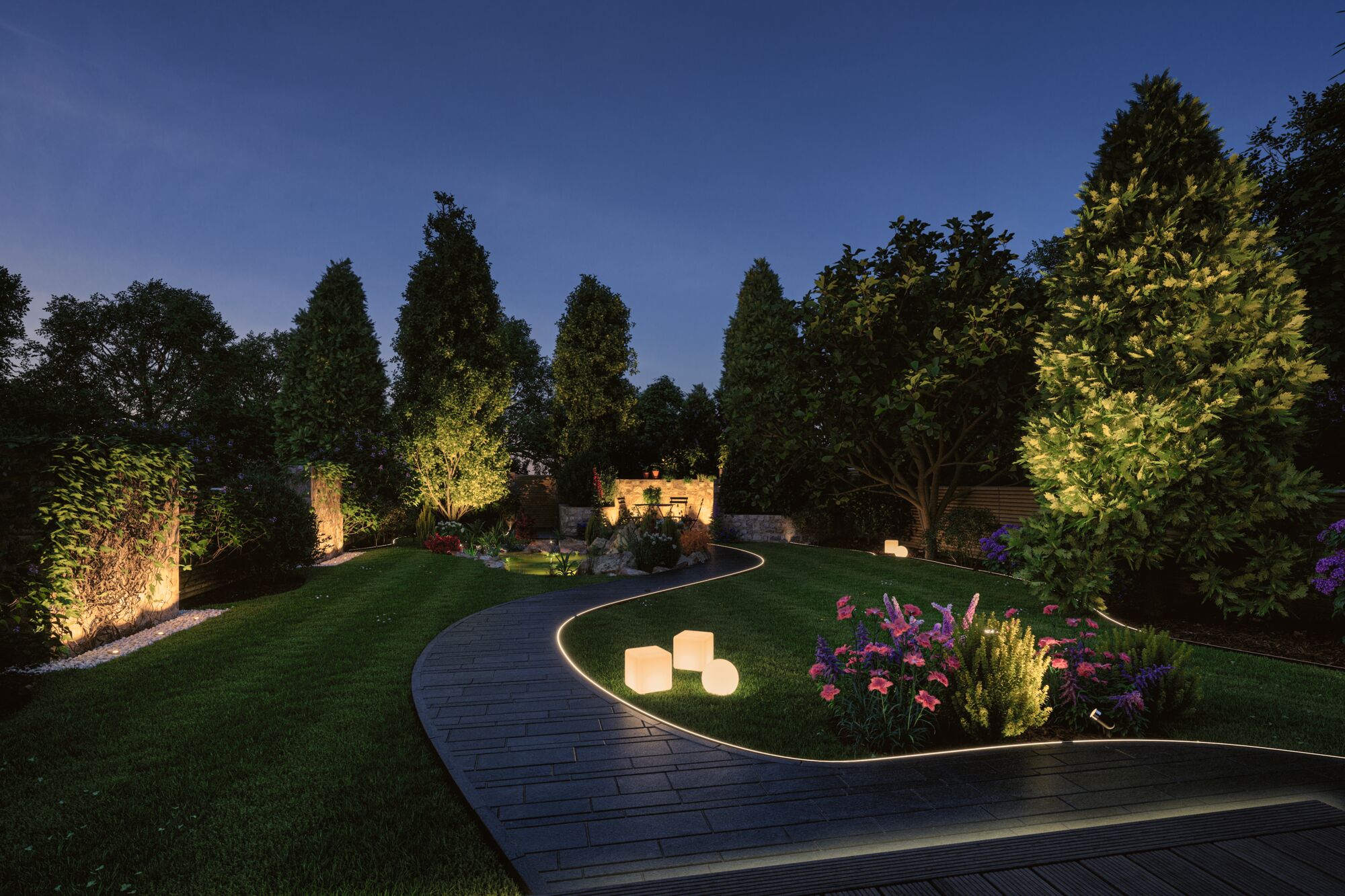 Allée de jardin éclairée avec spots LED encastrés et cubes lumineux dans un espace vert la nuit