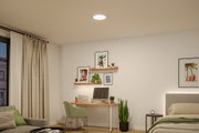Rundes LED-Deckenlicht in Weiß in modernem Schlafzimmer mit Schreibtisch und grüner Deko